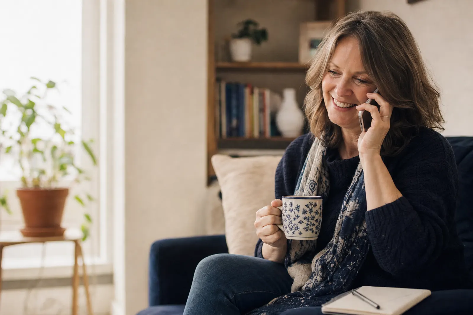 A follow-up volunteer smiles as she calls a first-time guest from her living room.